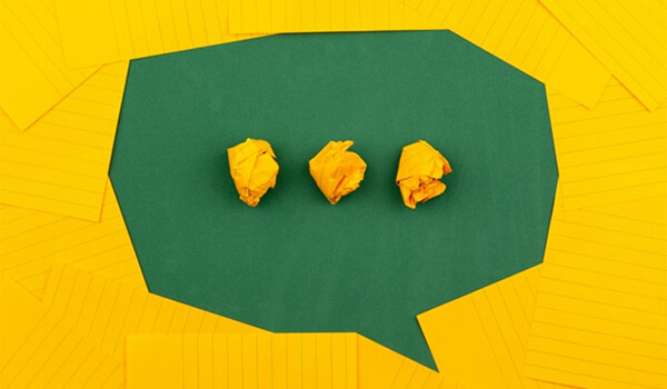 A speech bubble made from green and yellow paper.