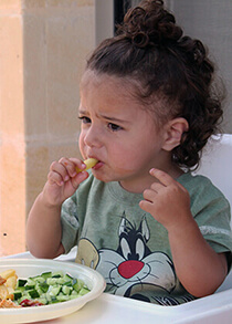 Toddler eating vegetables